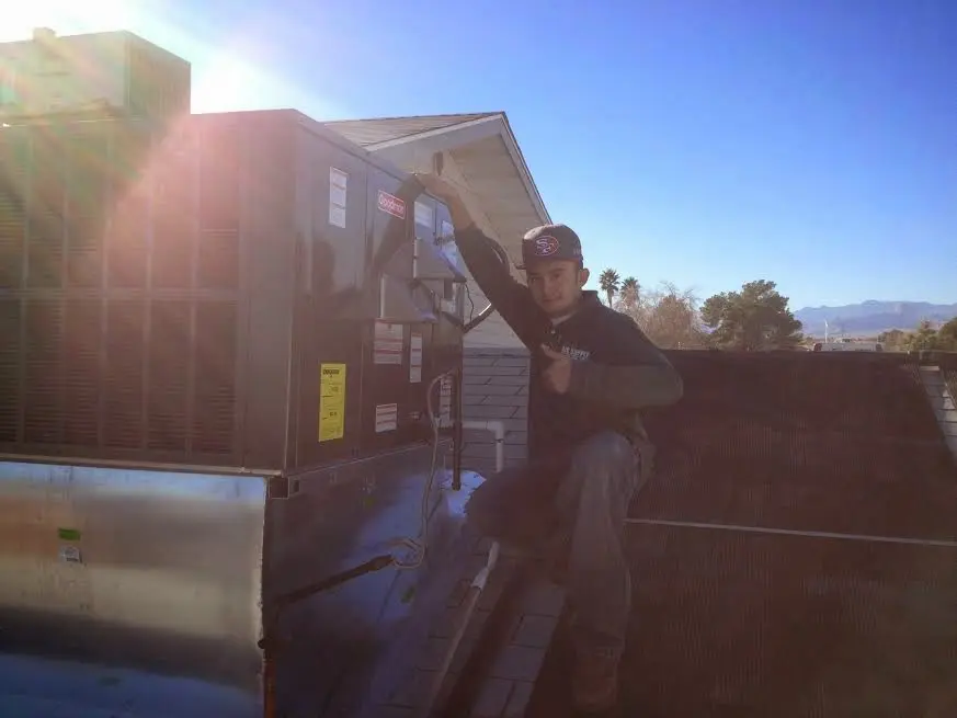 HVAC technician performing Heat Pump Repair on a rooftop unit in Newnan